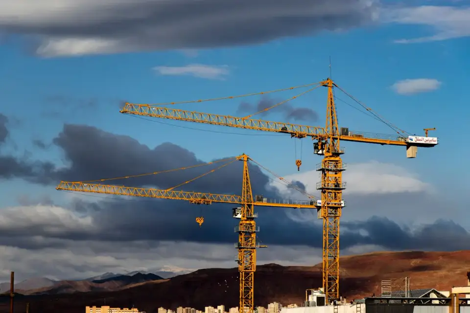 Şantiyede çalışan kule vinçler, gün batımı