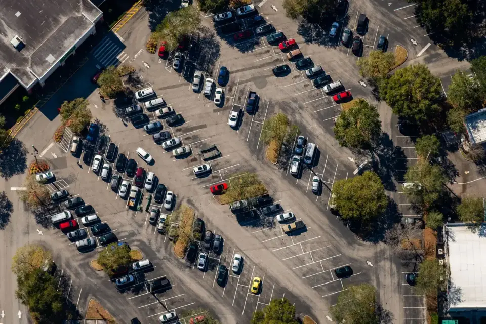 Ağaçlı açık otoparkta araçlar